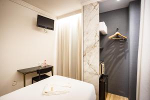 格拉纳达Hotel Dauro Premier的酒店客房配有一张床和淋浴