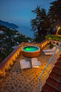 阿马尔菲Villa Nina Amalfi的楼梯旁的游泳池,配有2把躺椅
