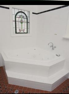 克莱尔克莱尔谷遗产住宿加早餐旅馆的白色的浴室设有浴缸和彩色玻璃窗。