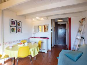 勒·雷约尔·卡纳德尔·苏尔Apartment Les Mas de Pramousquier-1 by Interhome的厨房以及带桌子和黄色椅子的用餐室。