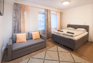 罗瓦涅米First Aparthotel Dasher的一间卧室配有一张床、一张沙发和一个窗口