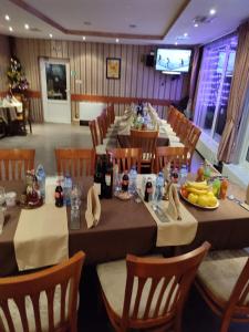 多斯帕特Хотел ПАНОРАМА ДОСПАТ的餐厅配有长桌子和椅子,提供食物