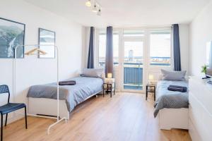 美茵河畔哈瑙Chic City-View Apartments in Hanau的一间卧室设有两张床和窗户。