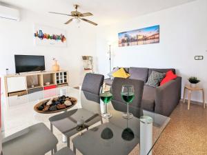 卡拉德费斯特拉特贝尼多姆克布郎卡公寓的客厅配有沙发和带酒杯的桌子