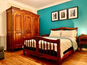 TonneinsPrivate Rooms & Bath的一间卧室设有一张木床和蓝色的墙壁