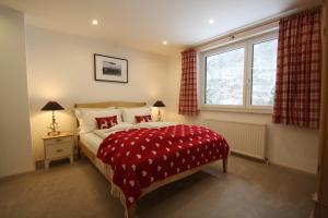 上特劳恩萨尔茨卡默古特豪斯旅馆的一间卧室配有一张带红色毯子的床和窗户。