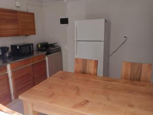 麦德林Road Living Home的厨房配有木桌和冰箱。