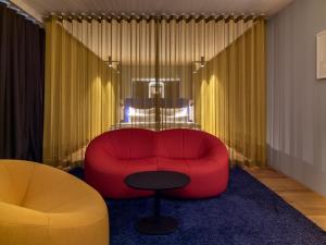 杜塞尔多夫b'mine hotel Düsseldorf的客厅配有红色的沙发和桌子
