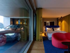 杜塞尔多夫b'mine hotel Düsseldorf的一间设有一张床和一辆车的卧室的房间