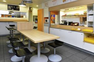 保拉扎克chicÔtel Périgueux Boulazac的厨房配有木桌和黑色椅子