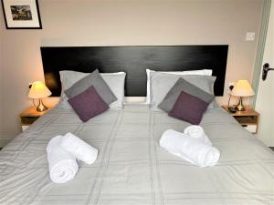 巴茅思Sunray Apartments的一张带白色毛巾和枕头的床