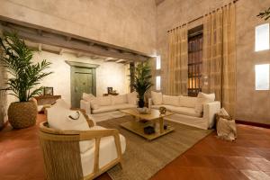 卡塔赫纳Moet Cartagena Hotel Boutique的大型客厅配有白色的沙发和桌子