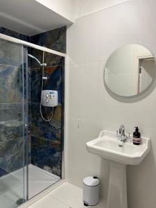 RameltonRiverfront Apartments at The Blue Goat Ramelton的白色的浴室设有水槽和淋浴。