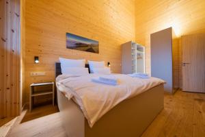 道恩NETTEN Naturerlebnis Holz-Chalets的一间卧室设有一张带木墙的大床