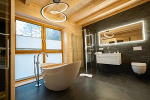 道恩NETTEN Naturerlebnis Holz-Chalets的一间带大浴缸和水槽的浴室