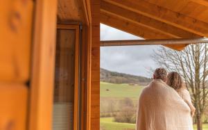 道恩NETTEN Naturerlebnis Holz-Chalets的一位新娘和新郎,从小屋的窗户望出去