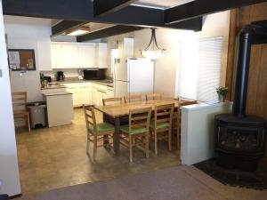 玛瑙湾Classic Carnelian Bay Log Cabin的厨房配有桌椅和炉灶。