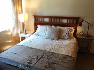 玛瑙湾Classic Carnelian Bay Log Cabin的卧室配有一张带白色床单和枕头的大床。