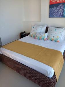 卡塔赫纳Apartamento frente a la playa的卧室配有一张带白色床单和枕头的大床。