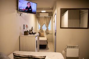 格拉玛多Hospedagem Vila Suiça Centro的客房设有两张床和一台墙上的电视。