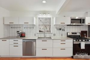 奥斯汀Affordable 3BR Home Near Airport and All Essentials的白色的厨房配有白色橱柜和水槽