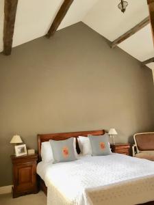 韦瑟比Garden Cottage的一间卧室配有带白色床单和枕头的床。