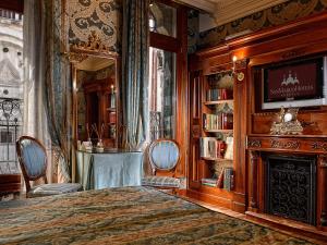 威尼斯Bellevue Luxury Rooms - San Marco Luxury的一间卧室配有一张床、一个壁炉和一台电视。