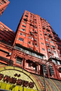 香港The Cultural Crashpad - 康乃馨旅館的一座高大的红砖建筑,前面有钟