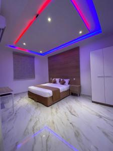 塔伊夫شاليهات غزال للفلل الفندقية الفاخرة的一间卧室配有一张红色照明的大床
