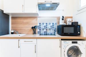 布雷斯地区布尔格SPACIEUX - Proche-gare - Parking的厨房配有微波炉,柜台上配有洗衣机