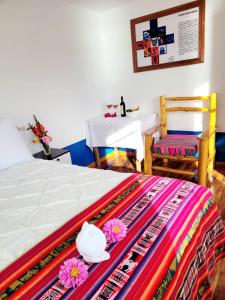 奥科苏尤Amantani Lodge的卧室配有1张床、1张桌子和1张桌子以及椅子。