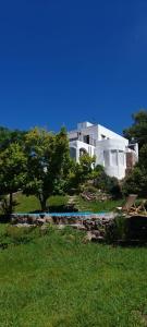 坦季La Flor del Camino Posada的绿色田野顶部的白色大房子