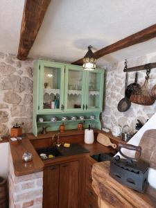 马卡尔斯卡Apartman Lidija的厨房配有绿色橱柜和水槽