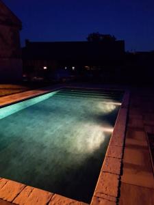 LukaChmelnice Luka的夜晚带绿灯的游泳池