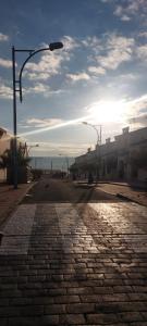 马塔拉斯卡尼亚斯Siorica Beach的一条有街道灯光和海洋的鹅卵石街道