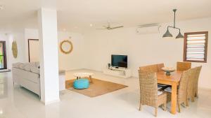 维拉港天堂角度假屋的客厅配有桌子和沙发