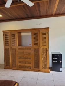 拉利伯塔德Kayu Surf Resort的一间带电视的大型木制橱柜