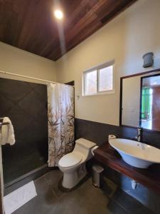 拉利伯塔德Kayu Surf Resort的浴室配有卫生间、盥洗盆和淋浴。