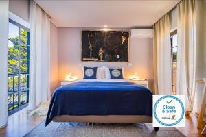 塞辛布拉7 bedrooms villa with private pool enclosed garden and wifi at Sesimbra的卧室配有蓝色的床和墙上的绘画作品