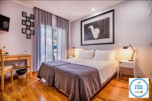 塞辛布拉7 bedrooms villa with private pool enclosed garden and wifi at Sesimbra的一间卧室配有一张床、一张书桌和一个窗户。