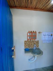 BarroquinhaBeira-mar Chácara Curimãs - Barroquinha, Ceará的浴室设有水槽和蓝色的浴帘