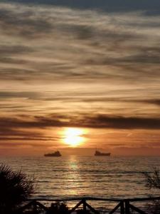 利沃诺Essenza del Mare Home的海上日落,水中船只