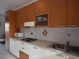 洛萨皮内塔Apartment Acquamarina-3 by Interhome的厨房配有白色橱柜、水槽和微波炉