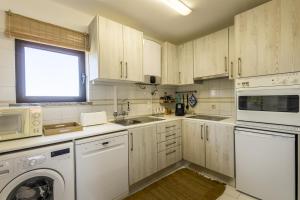 萨格里什Azul的厨房配有白色橱柜、洗衣机和烘干机
