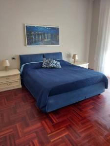 米兰Milano SanSiroHouse Rho MI Fiera的一间卧室配有蓝色的床和2个床头柜