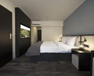 帕绍Hotel Innsento - Health Campus Passau的卧室设有一张白色大床和一扇窗户。