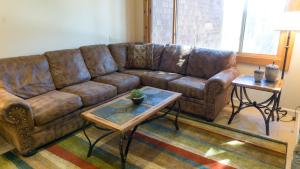 特拉基Ski Trails 4024的客厅里一张棕色的皮沙发,配有桌子