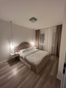 奥拉迪亚Jacuzzi Home的一间卧室配有一张大床和一张边桌