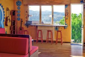 圣地亚哥－德孔波斯特拉Meiga Backpackers Hostel的带吧台的房间,配有凳子和窗户