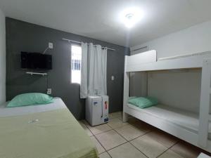 累西腓Casa Aeroporto Pousada的一间卧室配有两张双层床和电视